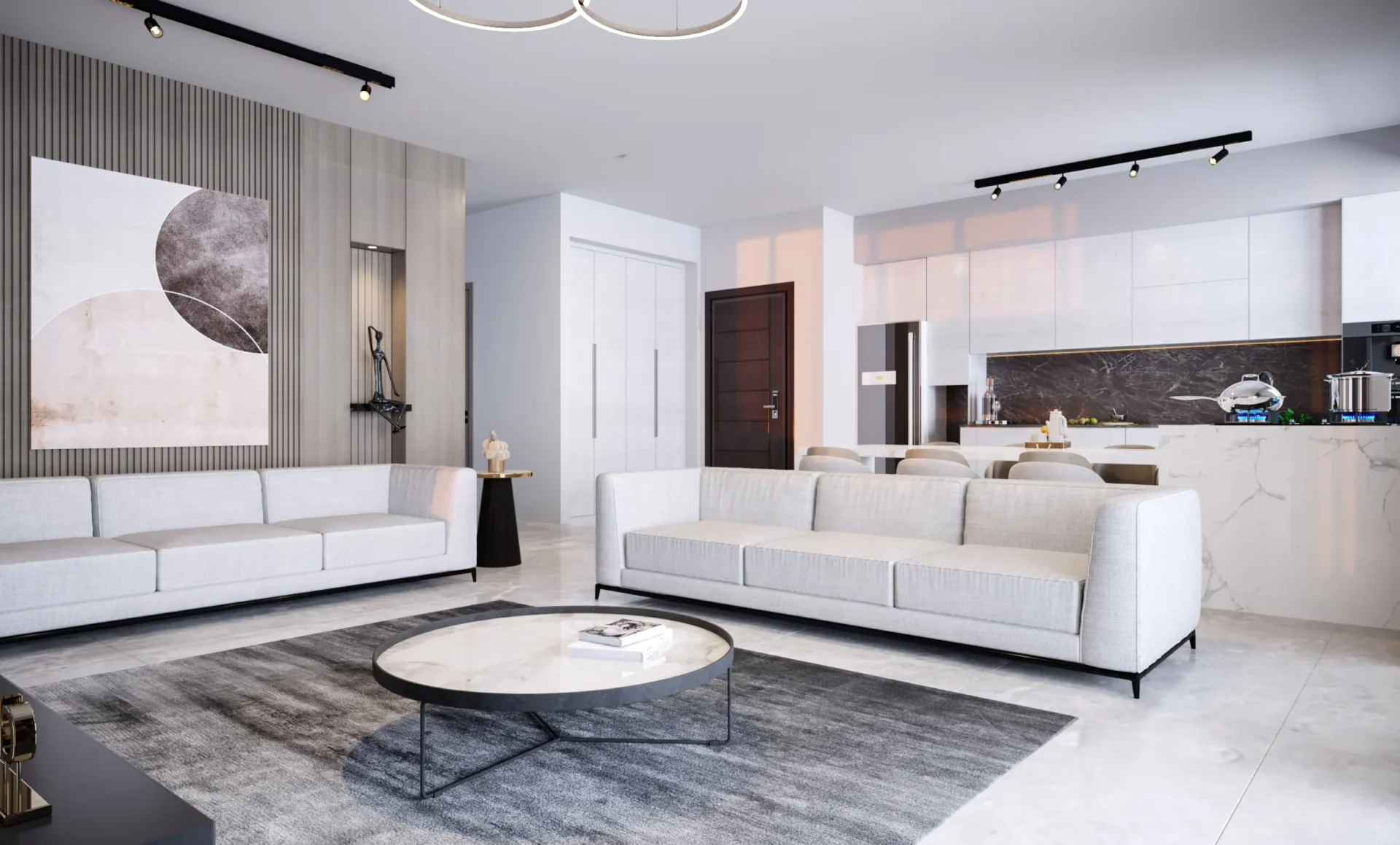 Alpcans Modern living room with two light gray sofas, a round marble coffee table, and a kitchen in the background. The room is decorated with a large wall art piece and has minimalistic decor.